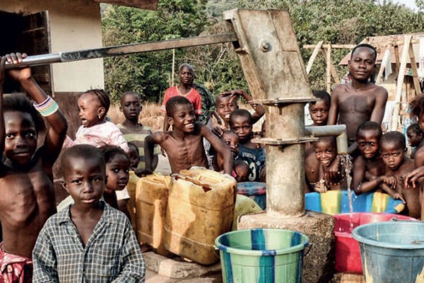 Ragazzi e donne di un villaggio in Sierra Leone che collaudano un pozzo