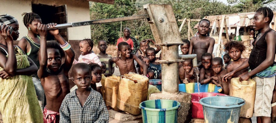 Ragazzi e donne di un villaggio in Sierra Leone che collaudano un pozzo